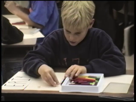 A male blond student is engrossed using plastic teahcing aids to figure out how to place 1/3rd on a number line